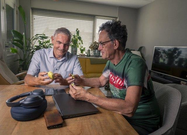 Een Techmaatje bekijkt thuis samen met een cliënt een hulpmiddel aan tafel